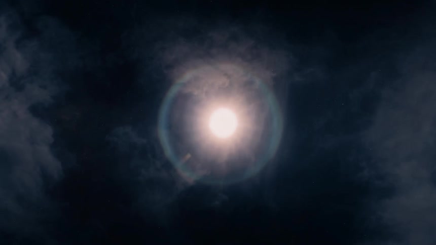 Full moon surrounded by clouds in the night sky