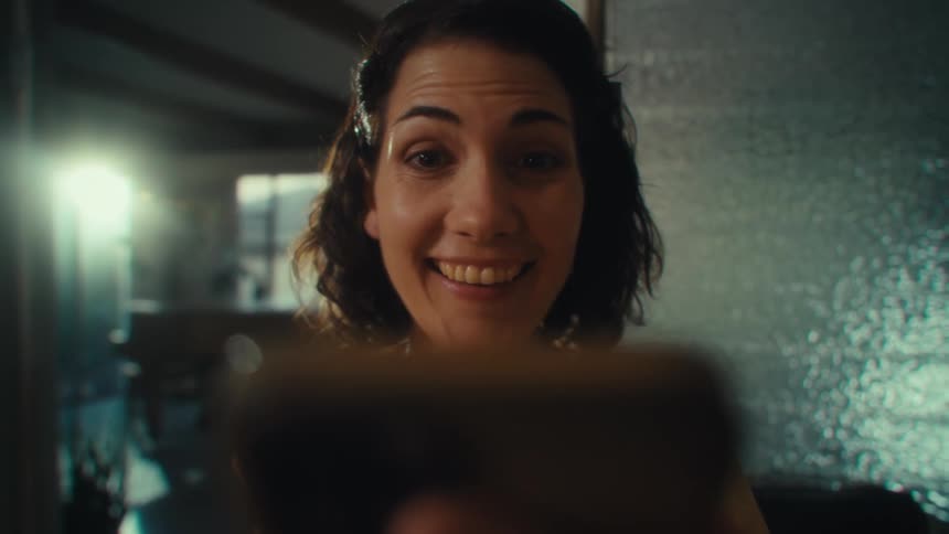 Woman staring intently at a cellphone she holds in front of her