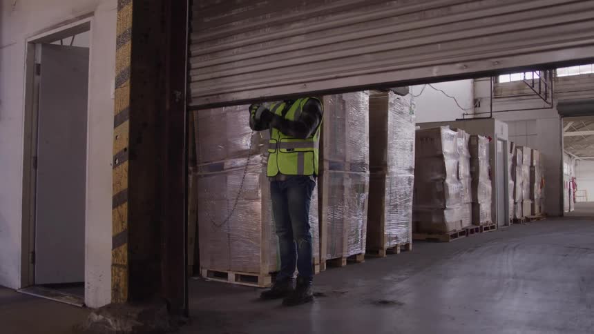A worker lowers a metal grate
