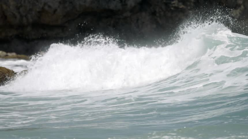 Waves crash into rock formations on the shoreline