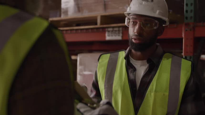Two workers are talking in the warehouse