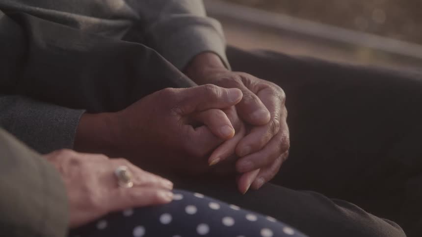 Two people holding hands in a gesture of affection