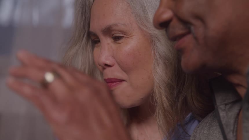 Woman smiling next to a man as they both look at something offframe