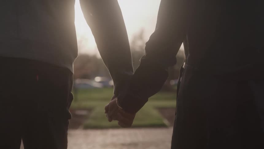 Couple holding hands walking outdoors
