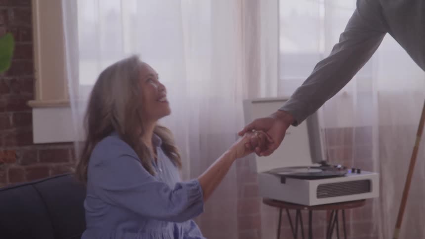 Man holding hands with a woman who is sitting