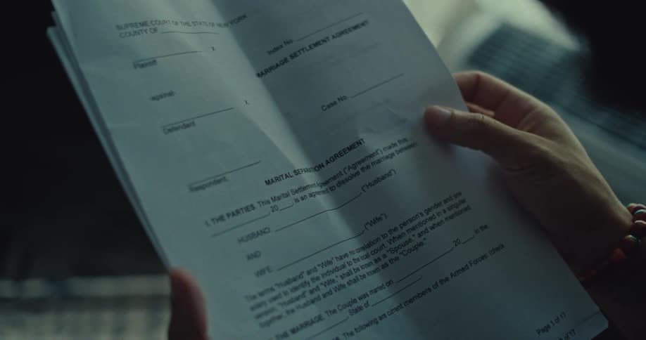 Person holds a multipage marriage settlement agreement
