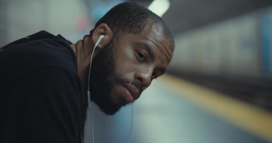Man sitting looking to the side while in a subway station