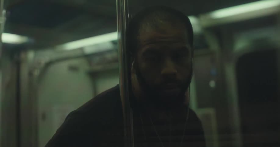 Man travels in subway train partly hidden by pole