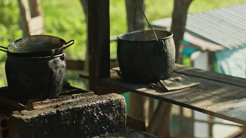 Two black pots on rustic outdoor stove