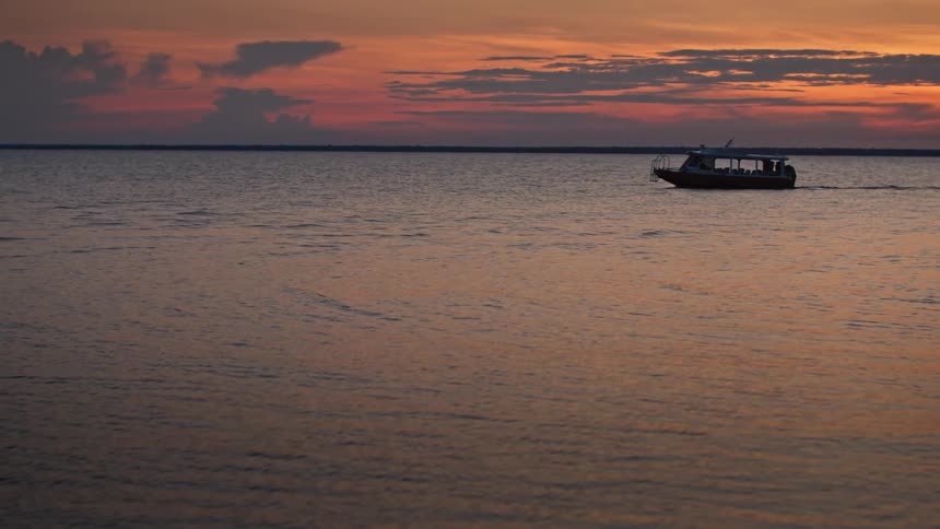 Boat sails on the sea during sunset