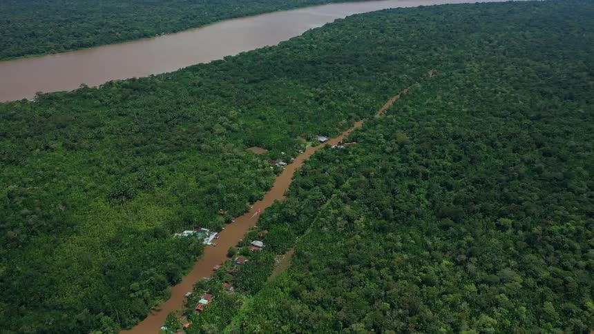 Aerial view of muddy rivers through dense forest villages