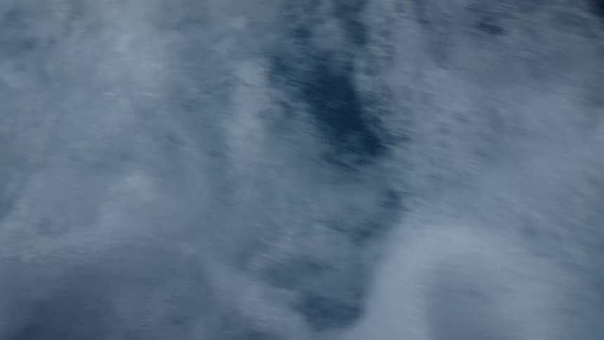 White foam forms on the choppy water surface