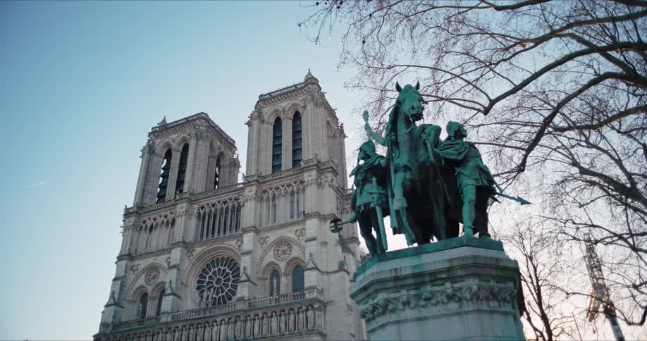 Facade of notredame cathedral with an equestrian statue in the foreground