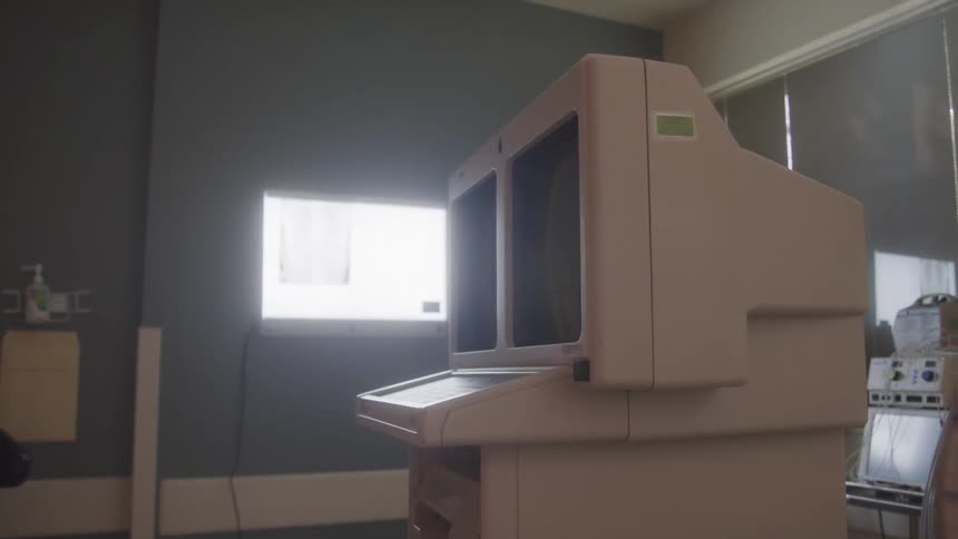 The video shows an offwhite retrolooking computer terminal similar to what might be found in a medical or scientific setting in the background a light source is visible behind a window