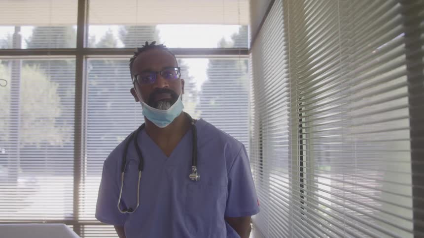 A doctor looks at the camera