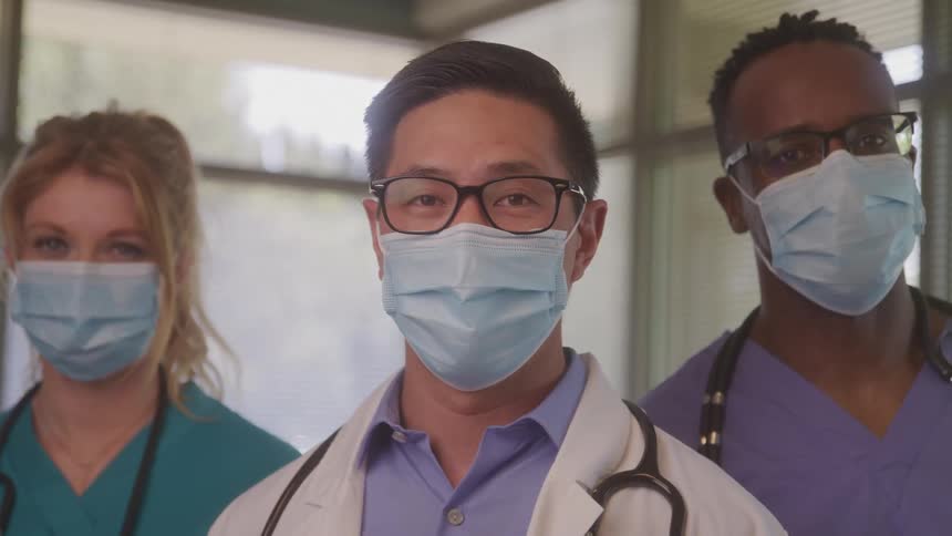 Three healthcare professionals wearing masks and stethoscopes