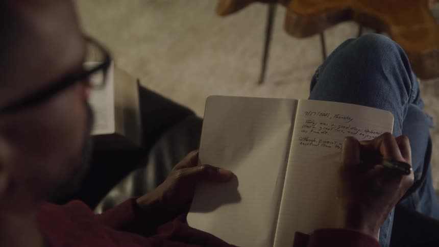 Person writing in a notebook with a pen
