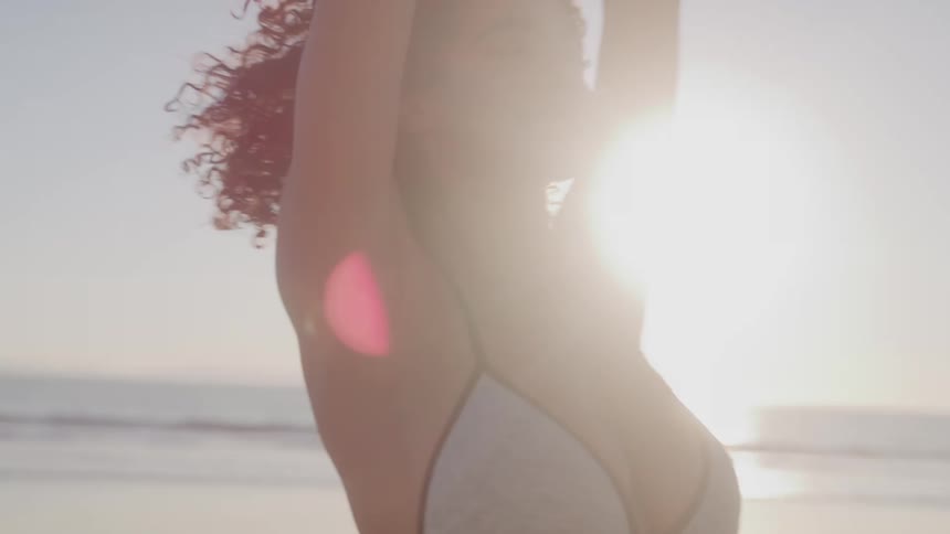 Woman in bikini on the beach with arms open
