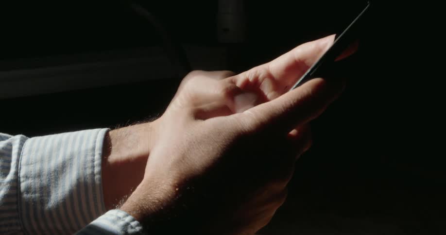 A man is typing fast on his cell phone