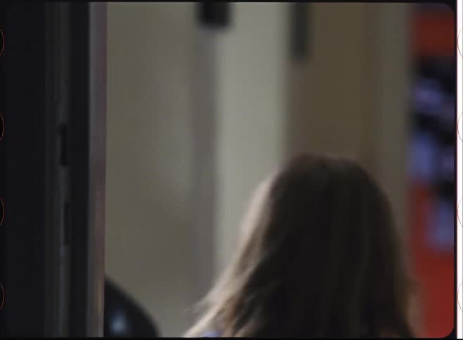 A girl child runs along a corridor in a house during daytime