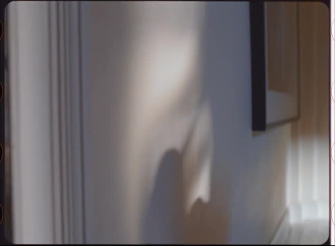A persons head is visible but the face is obscured by a film strip aesthetic the film strip has rounded corners and light leaks on the edges