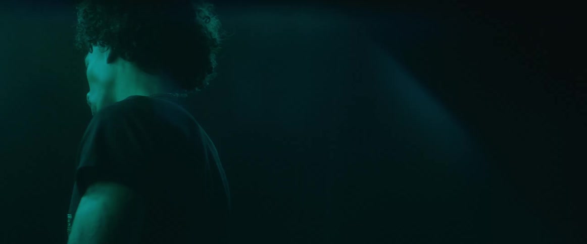 Man in profile illuminated by blue light in a dark environment