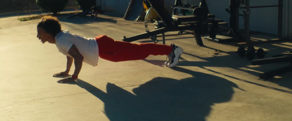 Person doing pushups outdoors in a workout area