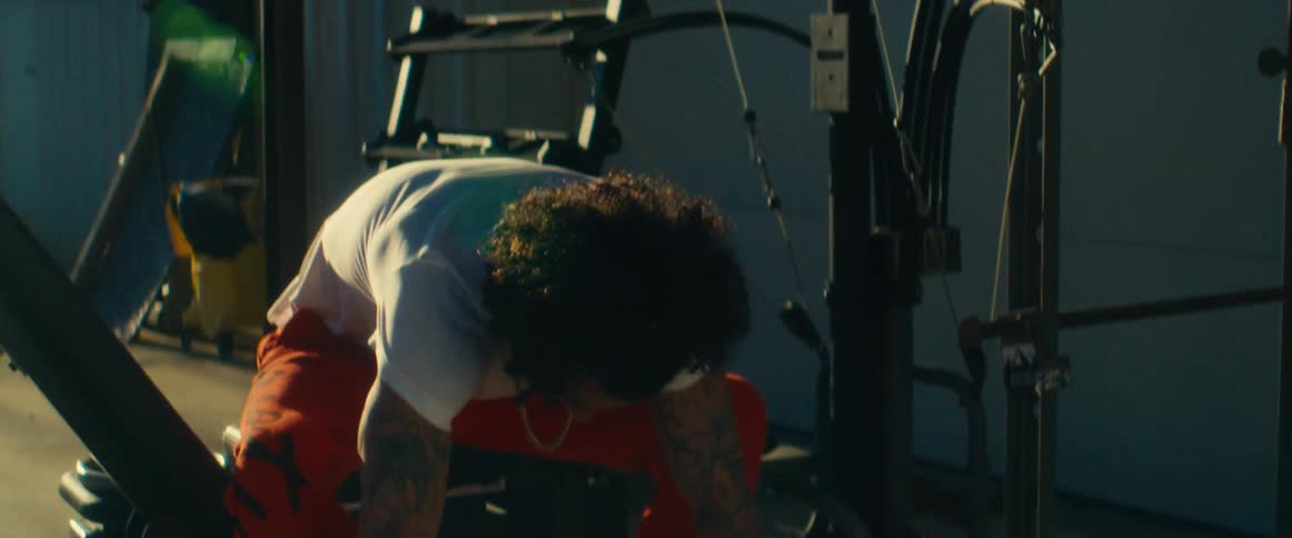 A young black man exercises at an outdoor gym during daytime
