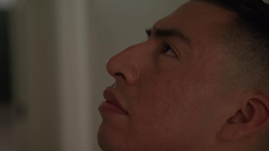 Close up portrait of a young man with his head tilted upwards contemplatively while indoors during daytime