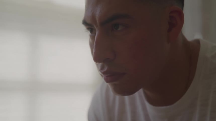 Close up portrait of a young man sitting in a room during daytime
