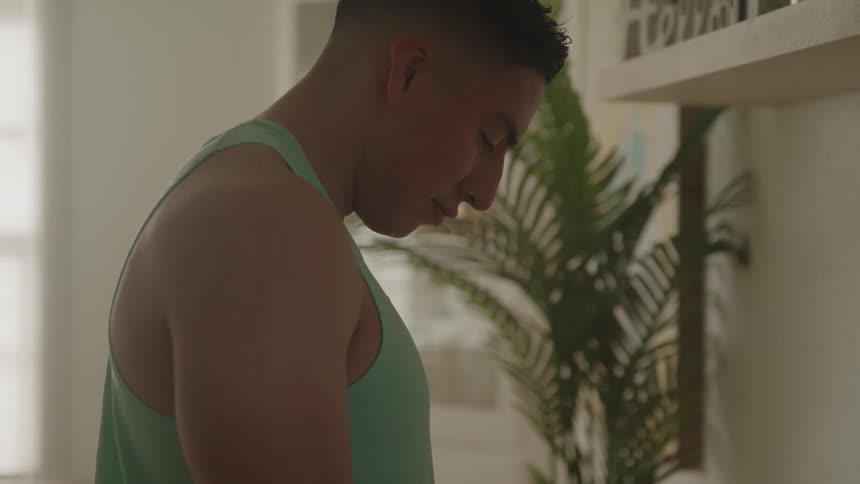 The man is standing in his home looking down