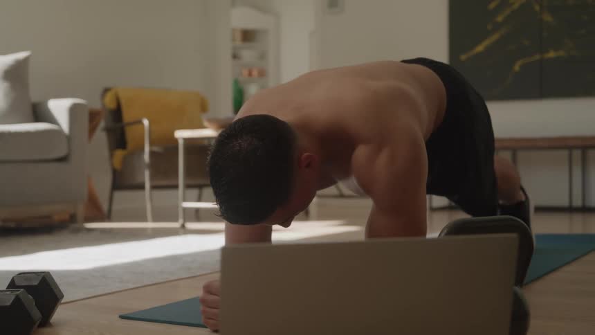 Man doing plank on a mat in the living room