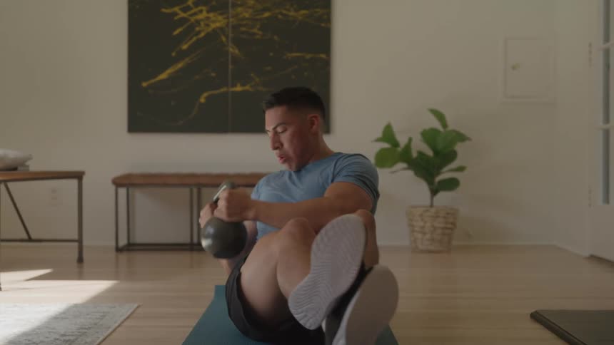 The man is using a kettlebell to exercise