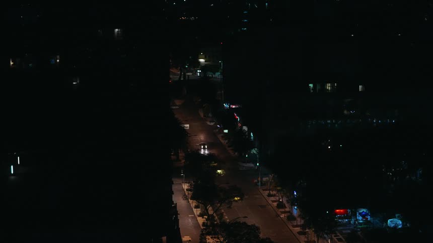 The video shows two lines of traffic driving away from the camera on a street at night the cars headlights are visible the scene is dark and the streetlights illuminate the road the video has a watermark that reads filmsupply