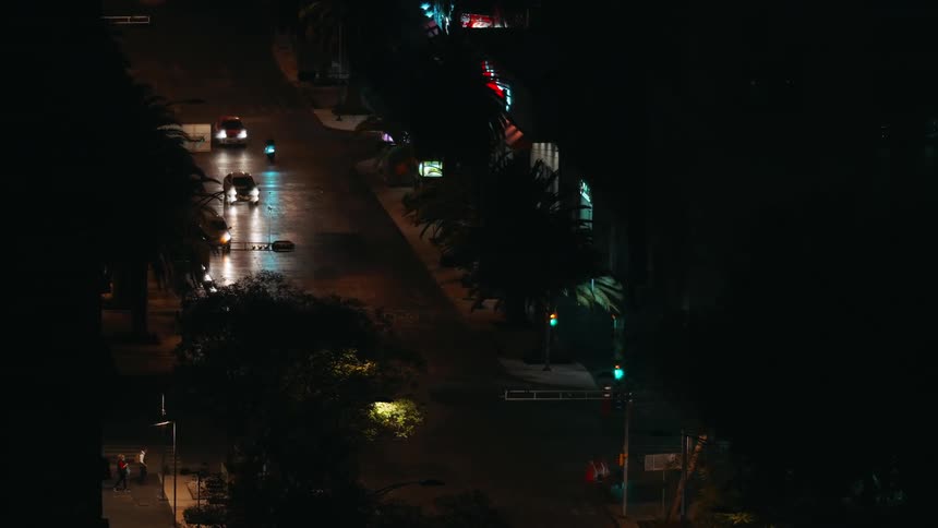 Cars drive down the street at night