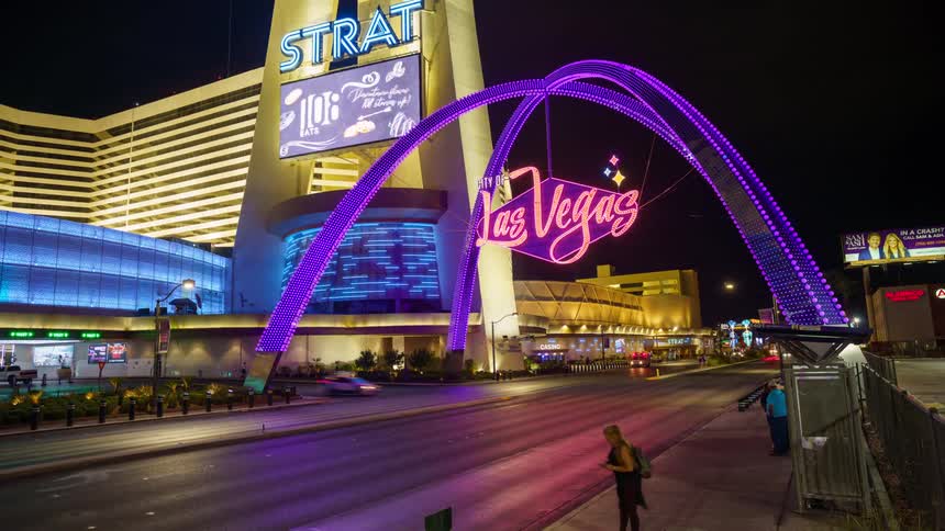 Las vegas street lit up at night with vehicle and pedestrian traffic