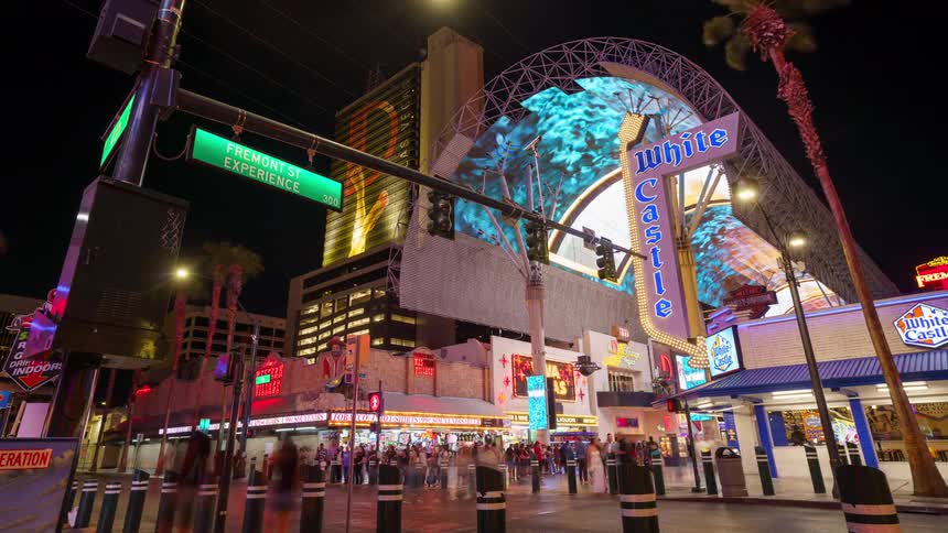 Crowd of people walking in downtown Las Vegas at night with shops and lights