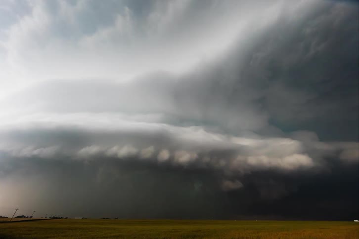 Dark storm clouds swirl over open plains