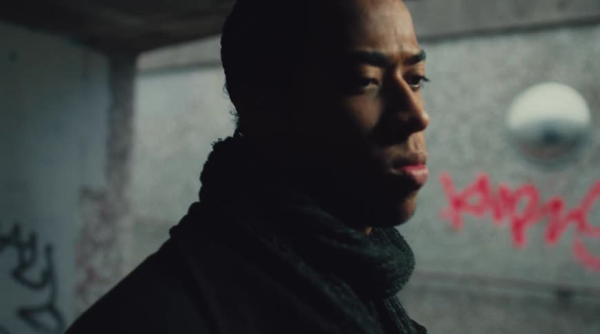 A womans profile is shown then a mans profile as he looks around in a dark graffiti covered space