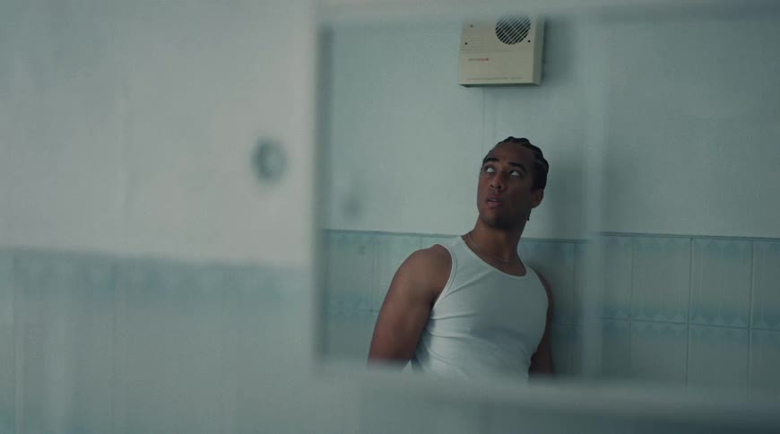 Man leans against bathroom wall slightly upset