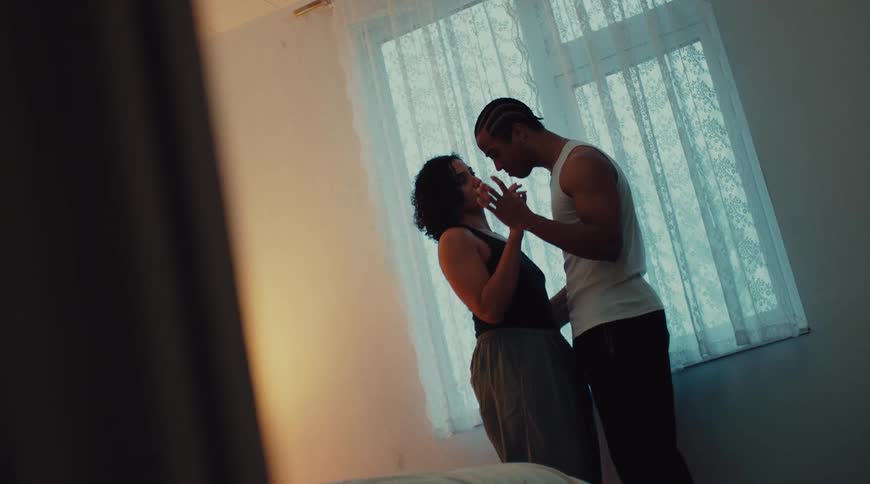 A couple shares a romantic and intimate moment indoors
