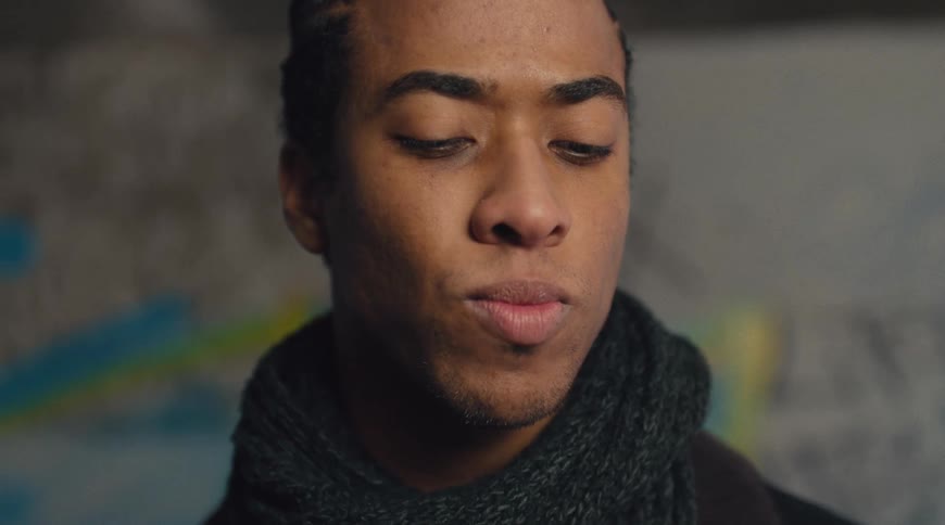 Man with a serious expression wearing a black scarf
