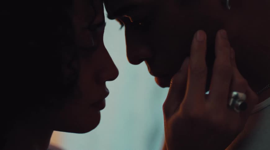 A young couple kisses and shows affection indoors