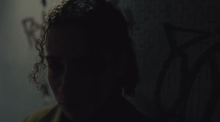 A young womans face is shown as she looks around with her facial expressions appearing to shift from thoughtful to distressed