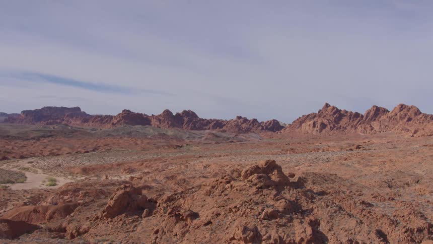 Rocky desert hills stretch across the landscape under a cloudy sky