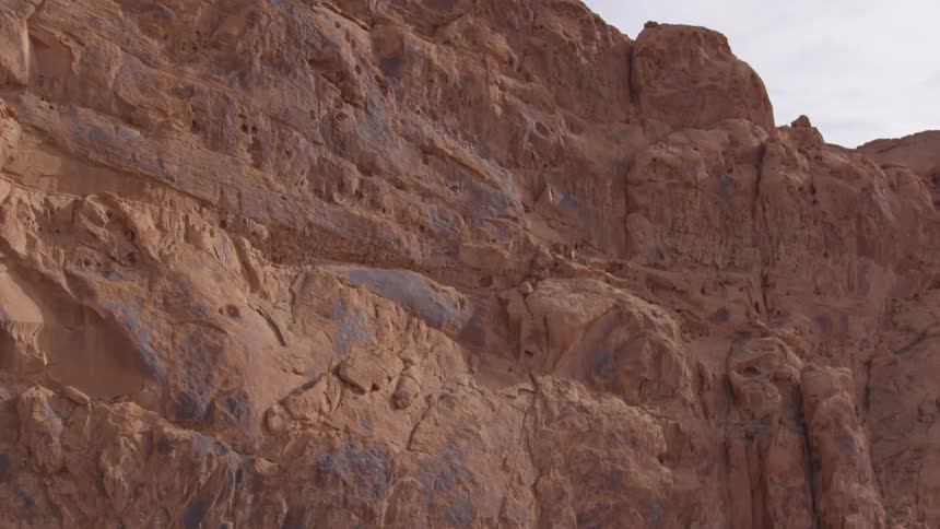 Reddish rock formations under a partly cloudy sky