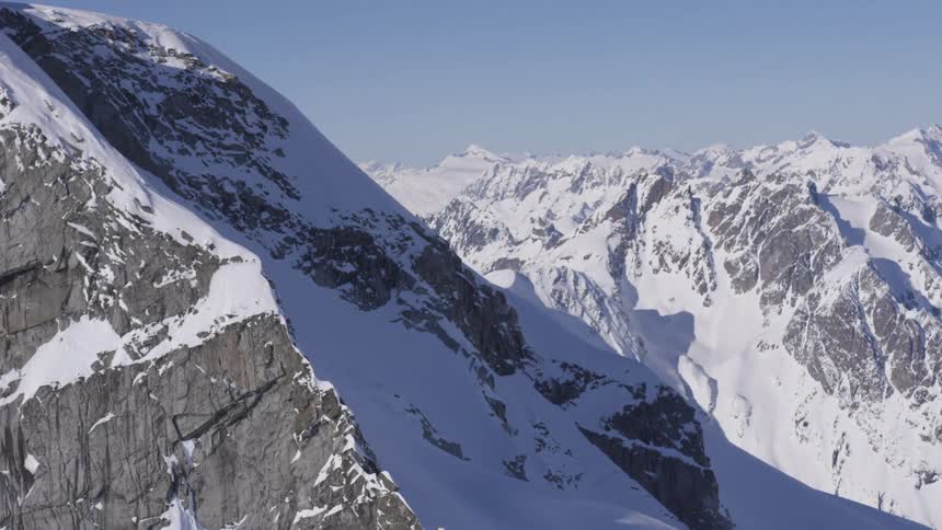 A rugged snowcovered mountain range on a sunny winter day