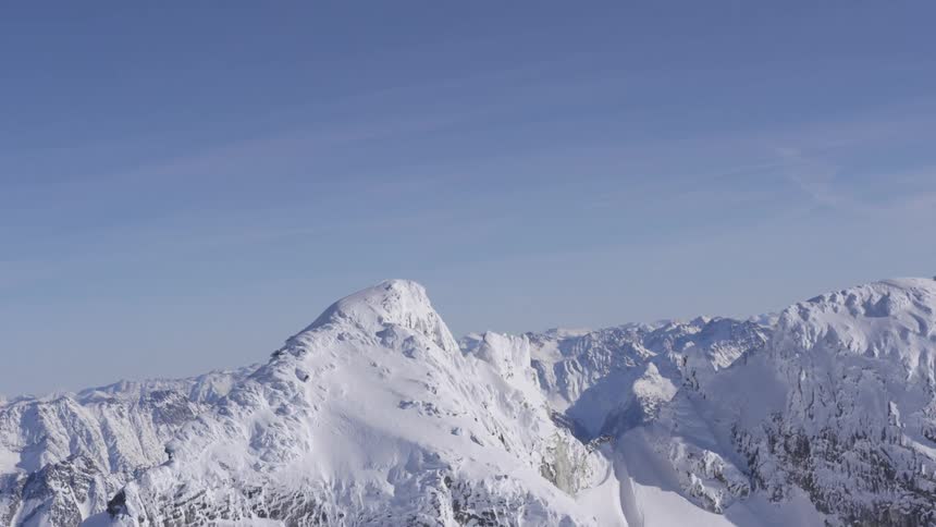 Snowcovered mountain surrounded by a range of snowy peaks