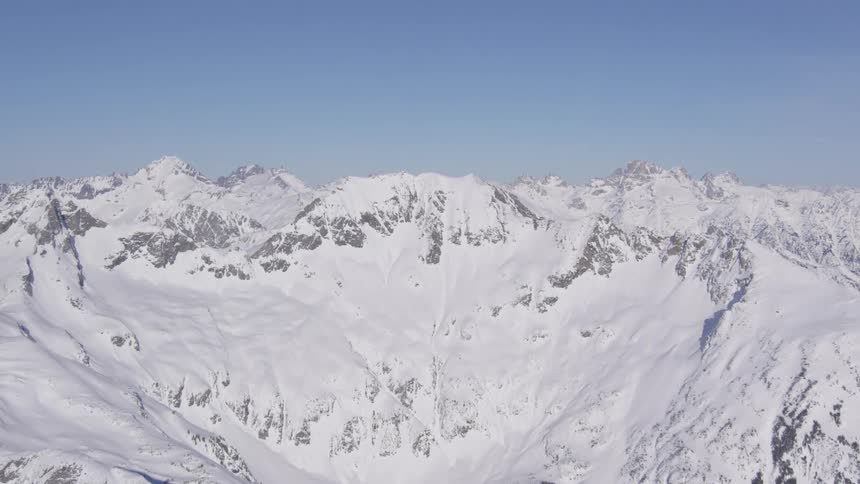 Snowcovered mountain range under a clear blue sky