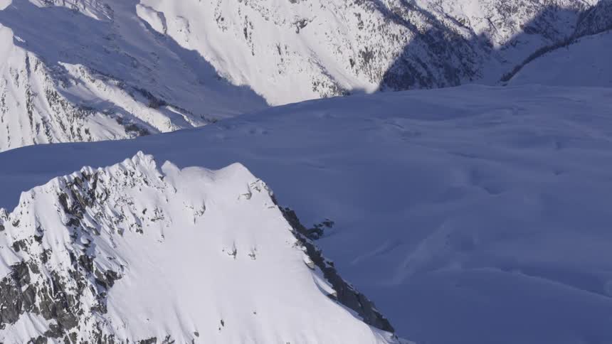 Snowcovered peaks and slopes under soft light